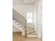 Elegant staircase with a wooden banister and black iron spindles with natural light at 11536 Serenbe Ln, Chattahoochee Hills, GA 30268