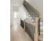 Bright foyer with a light-colored wooden staircase featuring black metal railing at 11536 Serenbe Ln, Chattahoochee Hills, GA 30268