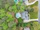 Overhead view of a brick house with a pool and manicured lawn, enveloped by lush trees in a private backyard at 250 Chason Wood Way, Roswell, GA 30076