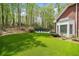Lush backyard features a brick home, a pool, mature trees, and artificial turf at 250 Chason Wood Way, Roswell, GA 30076