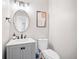 Neutral-toned bathroom features a grey vanity, white countertop, round mirror, and modern lighting at 250 Chason Wood Way, Roswell, GA 30076