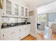 Butler's pantry features white cabinets, a sink, and a view into the dining room at 250 Chason Wood Way, Roswell, GA 30076