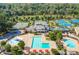 Aerial view of a community pool, tennis courts, and clubhouse amid lush greenery at 250 Chason Wood Way, Roswell, GA 30076
