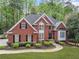 Charming brick home with lush green lawn, trimmed bushes, and a welcoming walkway to the front entrance at 250 Chason Wood Way, Roswell, GA 30076