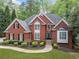 Classic brick home featuring a well-kept lawn, neatly arranged shrubbery, and a cozy, inviting front entrance at 250 Chason Wood Way, Roswell, GA 30076