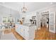 Bright eat-in kitchen boasts an island, white cabinets, stainless appliances, and hardwood floors at 250 Chason Wood Way, Roswell, GA 30076