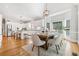 Open-concept kitchen flows to a dining area featuring white cabinets and an island with barstool seating at 250 Chason Wood Way, Roswell, GA 30076