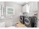 Laundry room with modern washer and dryer, utility sink, and overhead cabinets at 250 Chason Wood Way, Roswell, GA 30076