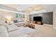 Large living room with a dark accent wall, neutral sectional sofa, wood coffee table, and natural light from windows at 250 Chason Wood Way, Roswell, GA 30076