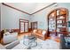 Stylish living room featuring a brown leather couch, gray chairs, built-in shelves, and elegant wood trim at 250 Chason Wood Way, Roswell, GA 30076