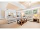 Spacious living room with neutral carpet, large sectional sofa, wooden coffee table, and an abundance of natural light at 250 Chason Wood Way, Roswell, GA 30076
