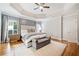 Large main bedroom features a tray ceiling, hardwood floors, and a seating area with a bench at 250 Chason Wood Way, Roswell, GA 30076