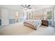 Neutral carpet, ceiling fan, two bedside tables and lamps in this spacious main bedroom at 250 Chason Wood Way, Roswell, GA 30076