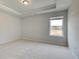 Bedroom features a tray ceiling, neutral walls, and a large window at 520 Dulles Dr, Mcdonough, GA 30253