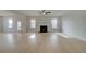 Open living room with a fireplace, ceiling fan, hardwood floors, and natural light at 520 Dulles Dr, Mcdonough, GA 30253