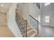 Grand staircase with wood and iron railings, leading to a light-filled foyer and open floor plan at 520 Dulles Dr, Mcdonough, GA 30253
