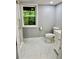 Bright bathroom featuring a modern toilet, marble floor and a window overlooking the trees at 1230 Sunderland Ne Ct, Brookhaven, GA 30319