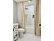 Bathroom with white marbled floors and a shower/tub combo with curtains and a brass shower head at 1230 Sunderland Ne Ct, Brookhaven, GA 30319
