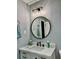 Stylish bathroom featuring a vanity with a round mirror, modern lighting, and elegant fixtures at 1230 Sunderland Ne Ct, Brookhaven, GA 30319