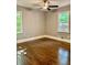Inviting bedroom features hardwood floors, a ceiling fan, and natural light from two windows at 1230 Sunderland Ne Ct, Brookhaven, GA 30319