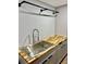 Close up of the stainless steel sink, wood countertops and matte black hardware in the laundry room at 1230 Sunderland Ne Ct, Brookhaven, GA 30319
