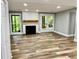 Inviting living room with a cozy fireplace, wood floors, and natural light from the windows and doors at 1230 Sunderland Ne Ct, Brookhaven, GA 30319