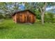 Rustic shed with wooden planking, nestled in a lush green lawn with mature trees at 14300 Veterans Memorial Highway, Villa Rica, GA 30180
