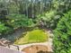 Overhead view of home's backyard featuring a fire pit, outdoor kitchen, picnic table and mature trees at 150 Victoria Sta, Woodstock, GA 30189