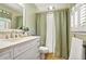 A charming bathroom featuring a vanity with a marble countertop and shower with patterned shower curtain at 150 Victoria Sta, Woodstock, GA 30189