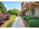 A stone walkway with lush landscaping leads to a charming home with wood siding and mature trees at 150 Victoria Sta, Woodstock, GA 30189