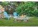 Cozy outdoor fire pit area with stone surround and Adirondack chairs, perfect for relaxing evenings at 150 Victoria Sta, Woodstock, GA 30189