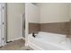 Bright bathroom showcasing a white bathtub with bronze hardware and tiled walls for a luxurious feel at 1945 Bay Beauty Ln # 10, Austell, GA 30106