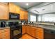Bright kitchen featuring wood cabinets, black appliances, and hardwood floors at 1945 Bay Beauty Ln # 10, Austell, GA 30106