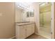 Bathroom vanity featuring granite countertop, framed mirror, and a tiled shower at 28106 Plantation Ne Dr, Atlanta, GA 30324