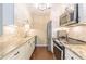 Galley kitchen boasts white cabinets, stainless steel appliances, and tile backsplash at 28106 Plantation Ne Dr, Atlanta, GA 30324