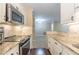 Galley kitchen features white cabinets, stainless steel appliances, and granite countertops at 28106 Plantation Ne Dr, Atlanta, GA 30324