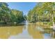 Scenic view of a pond with a fountain surrounded by lush trees at 28106 Plantation Ne Dr, Atlanta, GA 30324