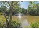 Picturesque view of a pond and fountain framed by mature trees and shrubbery at 28106 Plantation Ne Dr, Atlanta, GA 30324