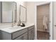Modern bathroom featuring a double vanity and a walk-in closet with hanging clothes at 3248 Shirecrest Ln, Dacula, GA 30019