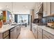 Open-concept kitchen with an island, modern appliances, light gray cabinets, and a view into the living area at 3248 Shirecrest Ln, Dacula, GA 30019