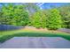 Lush backyard with a concrete pad and a privacy fence surrounded by mature trees offering shade and seclusion at 3460 Village Park Sw Ln, Atlanta, GA 30331