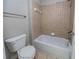 Bathroom showcasing a tub-shower combo with tile surround, toilet, and neutral tile flooring at 3460 Village Park Sw Ln, Atlanta, GA 30331