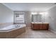 Bathroom with a large soaking tub, double vanity, and tile flooring at 3460 Village Park Sw Ln, Atlanta, GA 30331