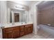 Bathroom features a double sink, wooden vanity, and bathtub shower at 3460 Village Park Sw Ln, Atlanta, GA 30331