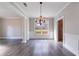 An empty Dining Room with hardwood flooring that is well lit by the natural light from a large window at 3460 Village Park Sw Ln, Atlanta, GA 30331