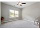 A bright and airy bedroom with a large window, ceiling fan and plush carpeting at 2410 Bridle Bridge Trl, Cumming, GA 30040
