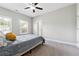 A cozy bedroom with plush carpeting, a ceiling fan, and natural light from a window at 2410 Bridle Bridge Trl, Cumming, GA 30040