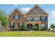Traditional two-story brick home with a manicured lawn and black shutters, offering classic curb appeal at 2410 Bridle Bridge Trl, Cumming, GA 30040
