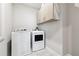 A functional laundry room featuring modern appliances and overhead storage at 2410 Bridle Bridge Trl, Cumming, GA 30040