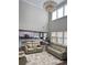 Spacious living room with high ceilings, many windows, an ornate chandelier and modern furnishings at 2410 Bridle Bridge Trl, Cumming, GA 30040